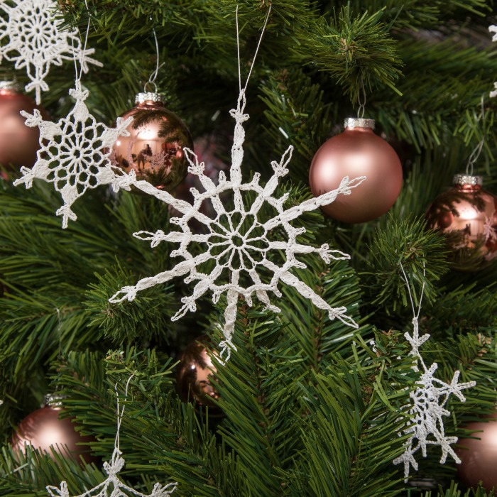 Karácsonyfa egyedi tervezésű kézműves csipke hópelyhekkel és csipke csillagokkal díszítve